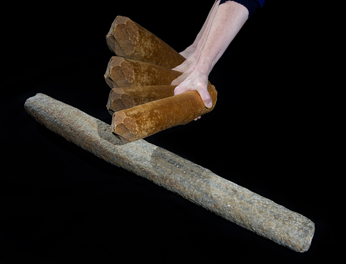 person bangs on a lithophone with a piece of wood