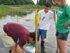 Postdoctoral Fellow Jed Goldstone (left) teaches Summer Student Fellows Thiago Parente (center) and Katie Barott to sample killifish.