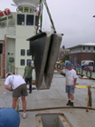 Rope alignment plates are clearly visible in this view of the stern sheave as it is hoisted into place in the stern of the Knorr.  
