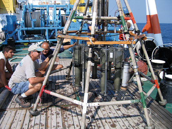 Aboard the Bulgarian R/V Akademik, research specialist Alan Gagnon (in the hat) and Bulgarian scientists inspect Niskin bottles during a Black Sea cruise with Assistant Scientist Marco Coolen. 
