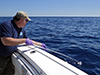 Bob Nelson using teflon dip net to collect oil from surface of Gulf of Mexico