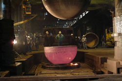 Still twice as thick as its will be when completed, the forged hemisphere cools. Later, material will be removed from both its interior and exterior to reduce its thickness to three inches and its overall outside dimension to 7 feet.