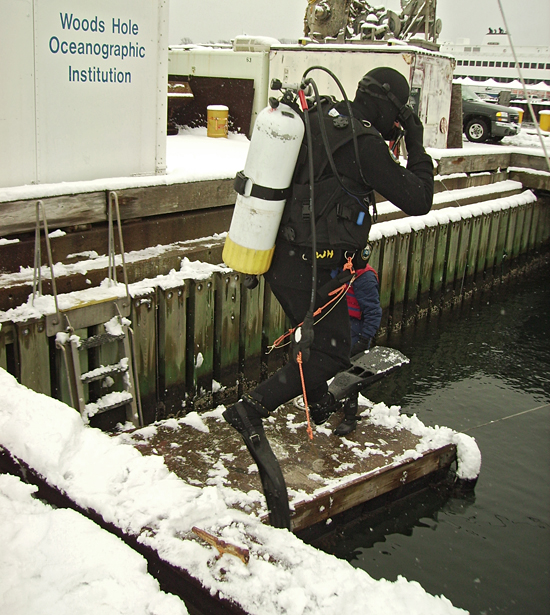 scuba diver jumping off WHOI dock in winter