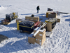 Arriving safely in Resolute, the many crates and bins of science gear are stacked up in the yard outside a research warehouse.