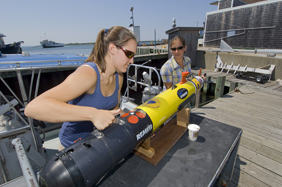 Working at the WHOI dock, summer student fellow Tess Brandon (Cornell University) and WHOI engineering assistant Amy Kukulya prepare a REMUS autonomous underwater vehicle for a research trip out to the waters off Martha's Vineyard. Working with physical oceanographer Al Plueddemann, Brandon studied the hydrodynamics of a submarine sand ridge.
