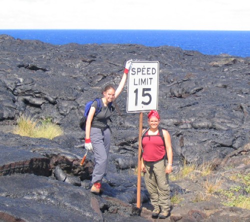 Margaret Boettcher and Jessica Williams assist the Kilauea Police Department in enforcing strict speed limits on lava flows. In actuality, this sign once marked the speed limit on a coastal highway that was covered by lava during the current Pu?u ?O?o-Kupaianaha eruption.