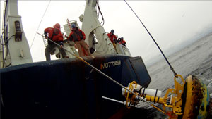 Jim Ryder and John Kemp (l to r) from WHOI's Mooring Operations, Engineering & Field Support Group work from the fantail of R/V Knorr to recover a surface mooring that was part of AST2.