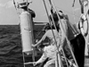 researchers on ship with person-sized sampling bottle