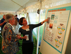 Fernanda Hoefel explaining her research to an Associate. 
