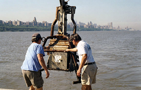 WHOI Senior Research Assistant Jay Sisson (left) and Engineer Craig Marquette maneuver a box corer after plucking a 30-centimeter-deep sample of sediment from the bottom of the Hudson River in June 2001.