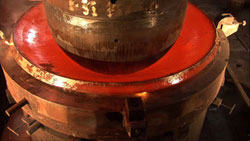 The titanium disc is placed on a ring die, and the male die is pushed through the disc to form the first of two hemispheres. Eventually the hemispheres will be welded together using a high-energy electron beam to form the submersible�s personnel sphere.