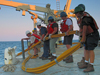 Chief Scientist John Goff (blue t-shirt and jeans) and other science staff are deploying a Vibracorer off the R/V Knorr.