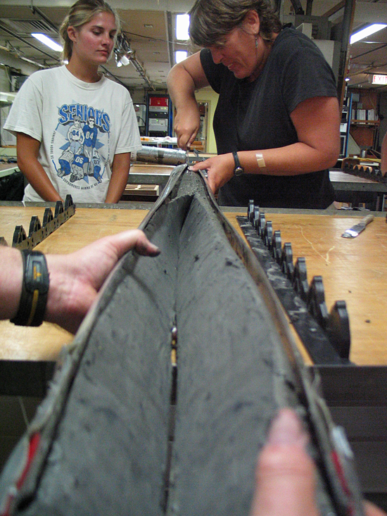 Amanda Uster (left) and Beth Christensen (right) opening a retrieved core on R/V Knorr.