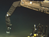 ROV Jason's manipulator arm inserts an injection pushcore into the seafloor near a DHAB