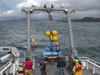 A large structure is deployed from the fantail of a research ship