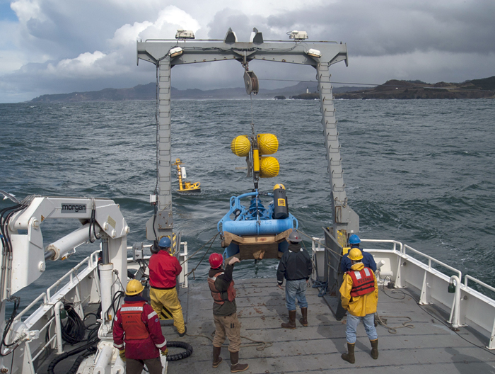 A large structure is deployed from the fantail of a research ship