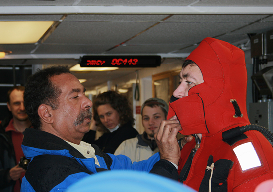 R/V Oceanus first mate Diego Mello (left) helps WHOI Postdoc Tim Shanahan get into his 'Gumby' suit.