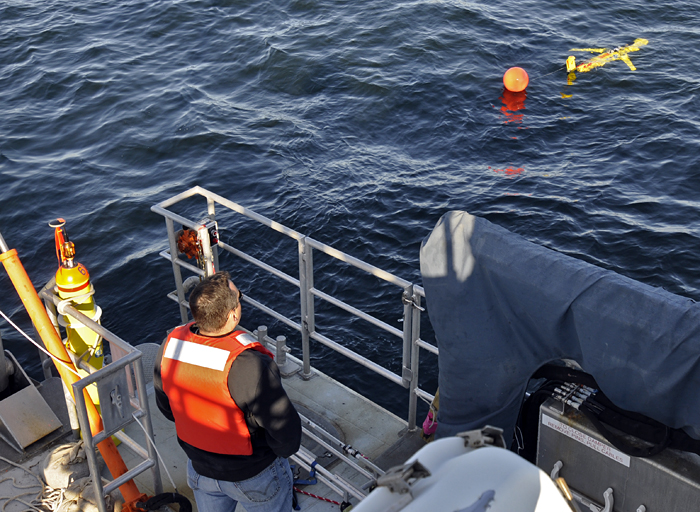 WHOI physical oceanographer Dave Fratantoni watches as a Slocum glider heads away from the ship during a test run