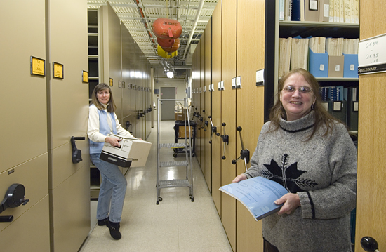 Ann Devenish and Ellen Levy working in the WHOI Data Library/Archives.