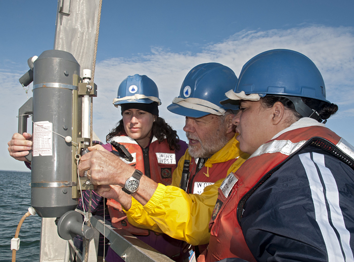 WHOI's Hovey Clifford (center) showed Melissa Simpson and Oniika Davis Peters from BP how to use a Niskin bottle to take water samples beneath the ocean surface recently.