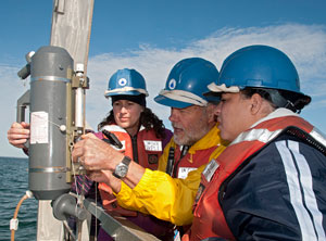 WHOI's Hovey Clifford (center) showed Melissa Simpson and Oniika Davis Peters from BP how to use a Niskin bottle to take water samples beneath the ocean surface recently.