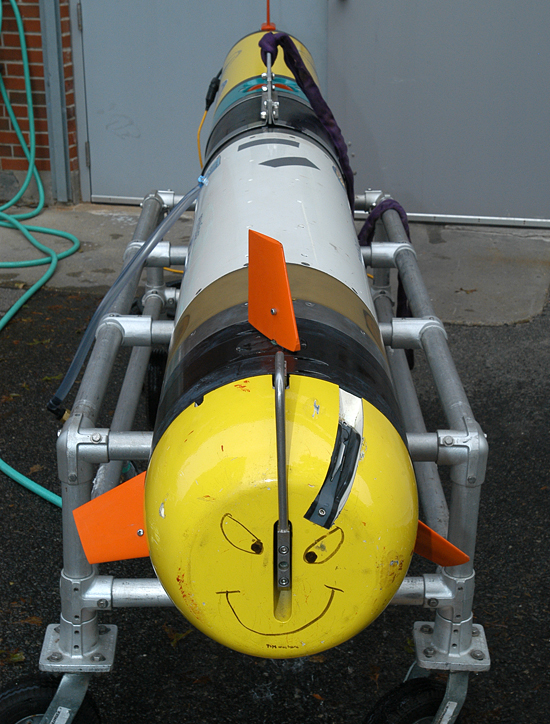 A REMUS-600 autononomous underwater vehicle sits on its cradle outside the Oceanographic Systems Lab. The AUV, which can dive to 600 meters, has a modular design to accommodate varying payloads and sensors. That large white section of the vehicle is the Small Synthetic Aperture Minehunter (SSAM), a high-resolution imaging sonar. 