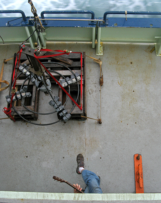 Ronnie Whims, AB on Oceanus, plays guitar on deck near a Craib corer.