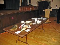 Image of long table on which are displayed samples of marine objects and oceanographic instruments
