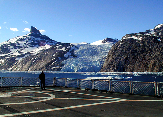 A tidewater glacier in Prinz Christian Sound on the southern tip of Greenland calves small bergy-bits as the USGC icebreaker Healy passes by.
