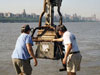 WHOI Senior Research Assistant Jay Sisson (left) and Engineer Craig Marquette maneuver a box corer after plucking a 30-centimeter-deep sample of sediment from the bottom of the Hudson River in June 2001.