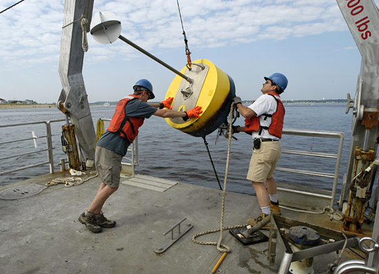 Postdoc Dave Ralston and Jay Sisson recover a mooring bouy.
