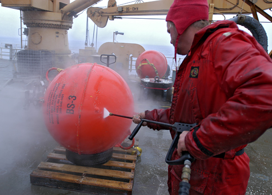 John Kemp powerwashing the mooring spheres.
