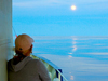 Messman Kathryn Eident, looks at the moon in the distance from the deck of R/V Oceanus.