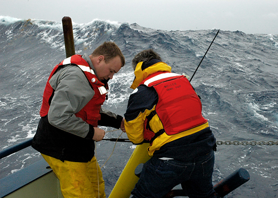 John Lund and Bob Weller deploy an APEX float off R/V Oceanus during rough weather.