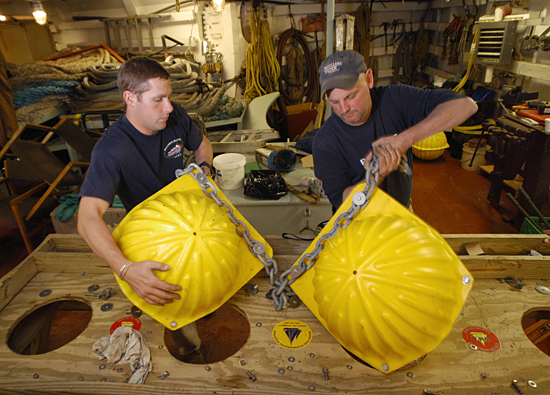 Kris Newhall and John Kemp examine and repair floats on board the Canadian icebreaker Louis S. St-Laurent.