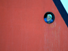 From onboard the Canadian icebreaker Louis St-Laurent, Steward Judith Joncas peers out from a porthole.