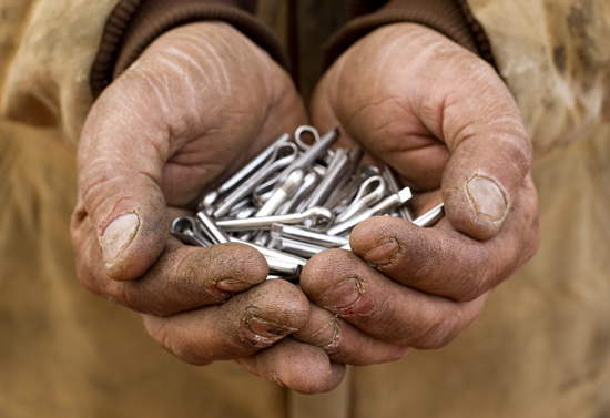 A handful of fasteners held by a crewman.