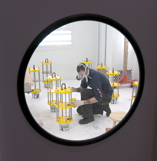 PO Engineering Assistant Brian Hogue in the paint booth spraying instrumentation componenents.
