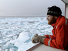 Jeremy Kaspar, a student at the University of Alaska, Fairbanks, keeps a watchful eye on the icy ocean from onboard USCG Healy.