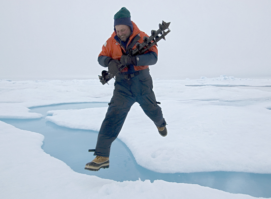 John Kemp leaping across ice gap carrying drill bits for ITP deployment.