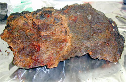 Rusty-orange iron oxide coats the left side of this sample of seafloor rock