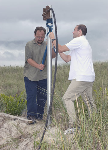 Assistant Scientist Liviu Giosan (tan shirt) and Graduate Student Jonathan Woodruff extract sediments from the beach using a vibracorer.