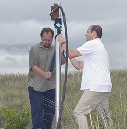 Assistant Scientist Liviu Giosan (tan shirt) and Graduate Student Jonathan Woodruff extract sediments from the beach using a vibracorer.