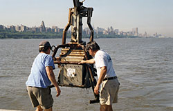 WHOI Senior Research Assistant Jay Sisson (left) and Engineer Craig Marquette maneuver a box corer after plucking a 30-centimeter-deep sample of sediment from the bottom of the Hudson River in June 2001.