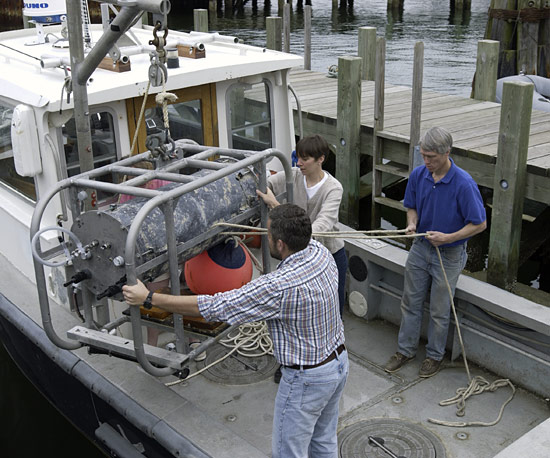 WHOI researchers Alexi Shalapyonok, Heidi Sosik, and Robert Olson (left to right) carefully load the FlowCytobot onto a WHOI research vessel for installation on the seafloor at the Martha’s Vineyard Coastal Observatory.