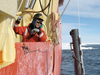 Working in open water in Antarctica's Ross Sea, Assistant Scientist Mak Saito deploys a water sampler from the R/V Nathaniel Palmer.