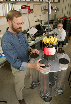 Ken Buesseler examines a neutrally buoyant sediment trap (NBST), while engineer Jim Valdes looks on.