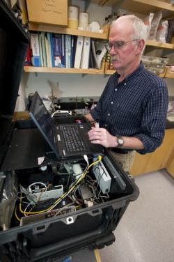 Scott Gallager works on the Swimming Behavioral Spectrophotometer to analyze the safety of a water sample. (Photo by Tom Kleindinst, Woods Hole Oceanographic Institution)