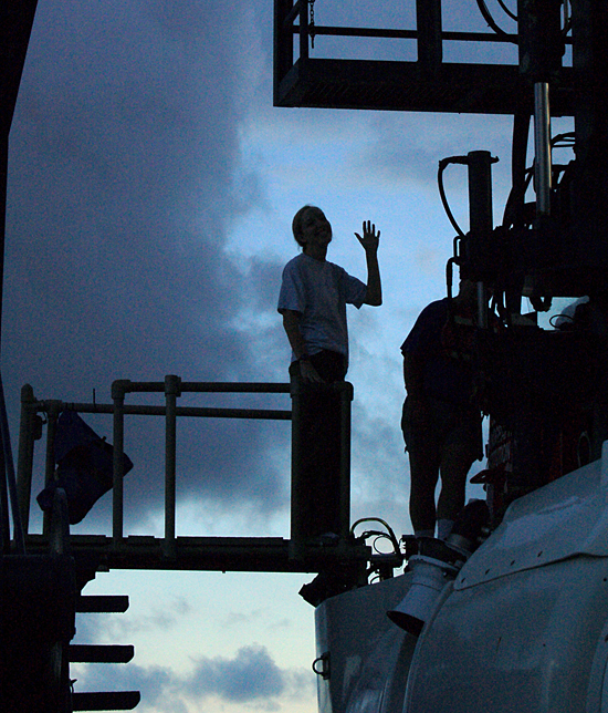Silhouette of Biology Joint Program student Carly Strasser waving so long before boarding Alvin.