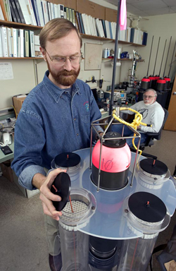 Marine chemist Ken Buesseler examines a neutrally buoyant sediment trap, while engineer Jim Valdes looks on.